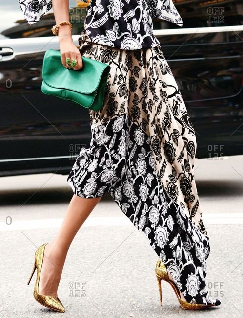 Paris, France - September 21, 2018: Woman wearing floral dress and carrying green purse