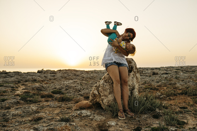 Mother and daughter enjoying the sunset in a very nice moments