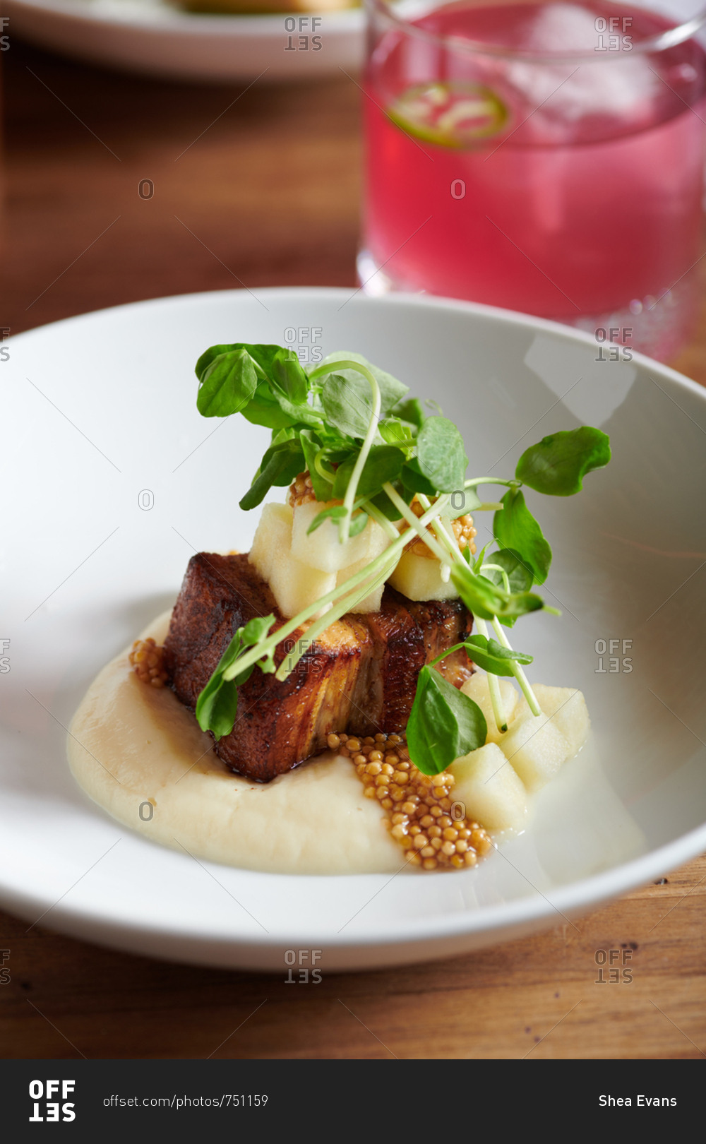 A tapas style dish of pork belly with apples, parsnip puree and pickled mustard seeds and pea