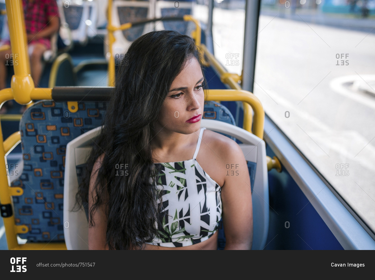 High angle view of thoughtful serious woman looking through window while sitting in bus