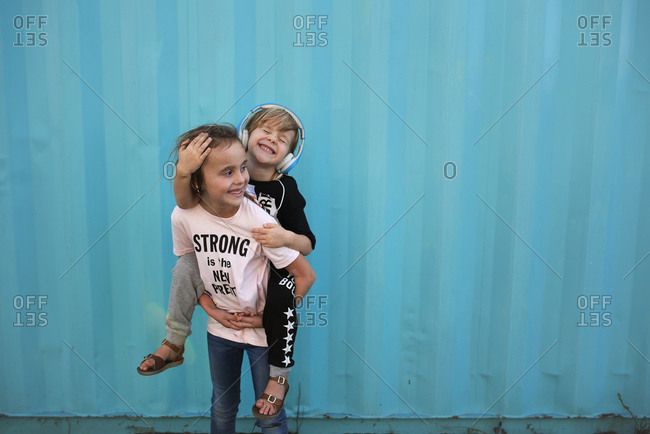 Young girl carrying sister giving piggyback ride Stock Photo