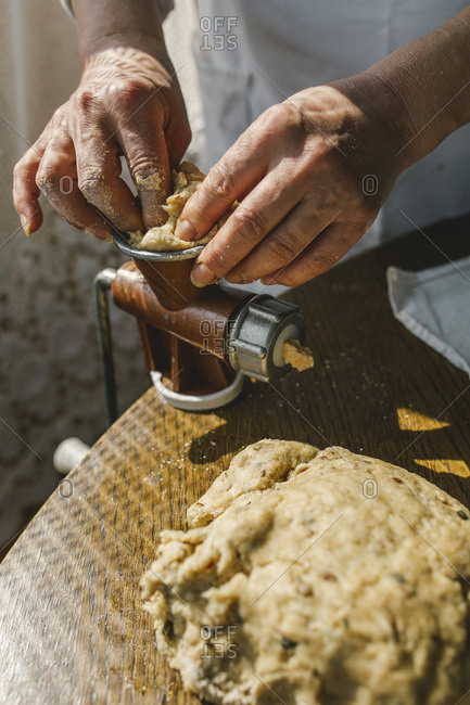 Woman Preparing Homemade Dough in the Kitchen and using a mincing machine. Preparation Raw Dough for Baking