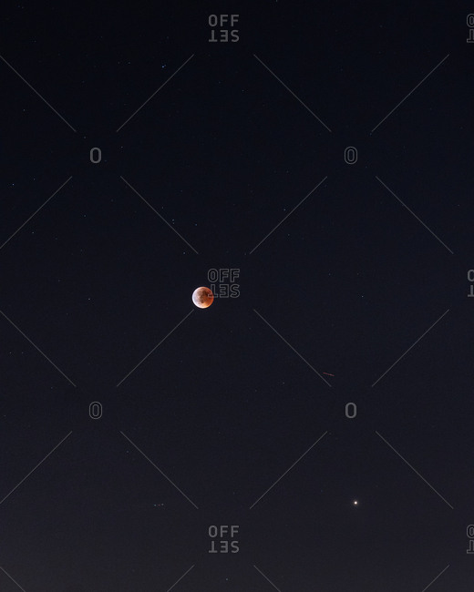 Amazing blood moon on dark night sky during eclipse in Madrid, Spain