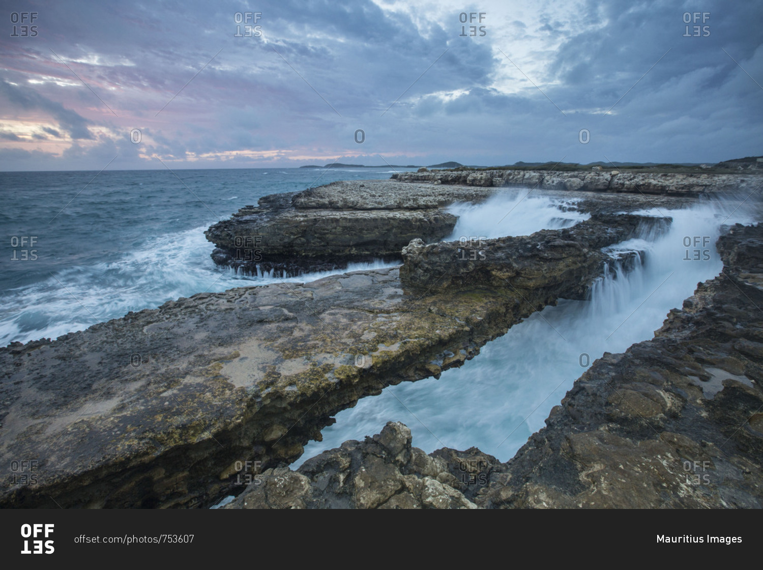 Sea waves crashing on the cliffs framed by sunset Devil\'s Bridge Antigua and Barbuda Leeward Islands West Indies