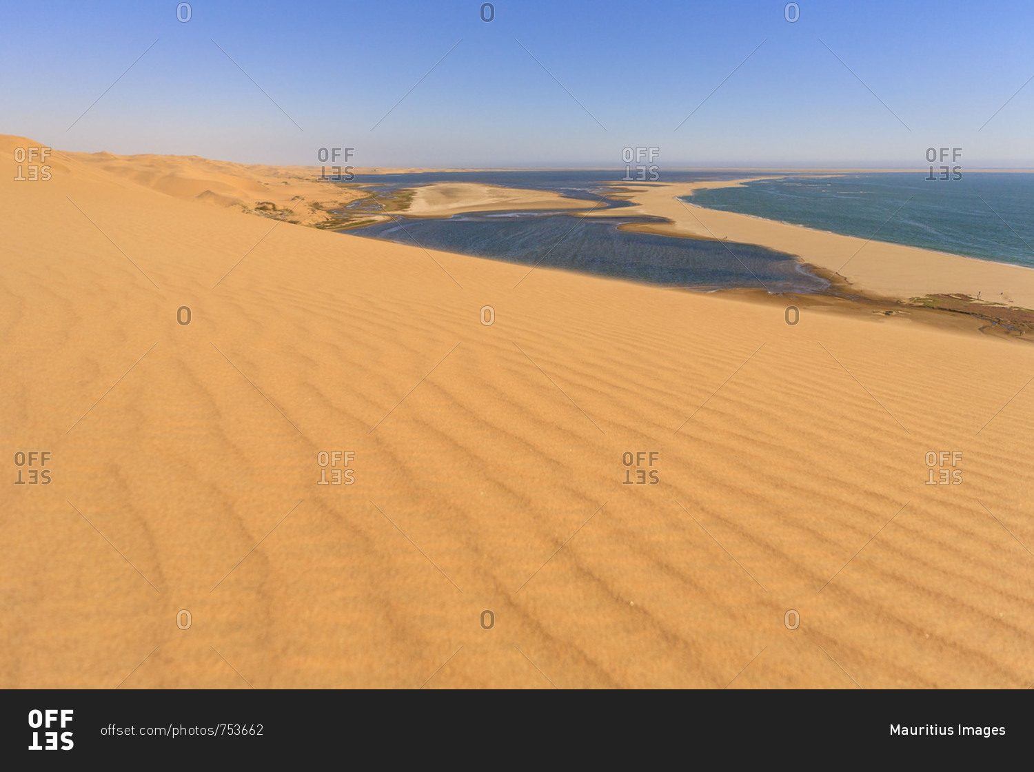 Sand dunes modeled by wind meet the Atlantic Ocean and lagoons in Walvis Bay Namib Desert Erongo Region Namibia Southern Africa