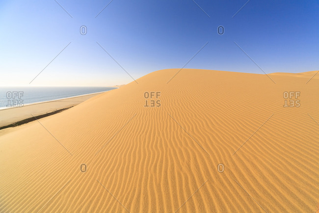 Sand dunes modeled by wind meet the Atlantic Ocean Walvis Bay Namib Desert Erongo Region Namibia Southern Africa