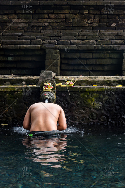 man bathing in the waters of the Tirta Empul Water Temple, Ubud, Bali