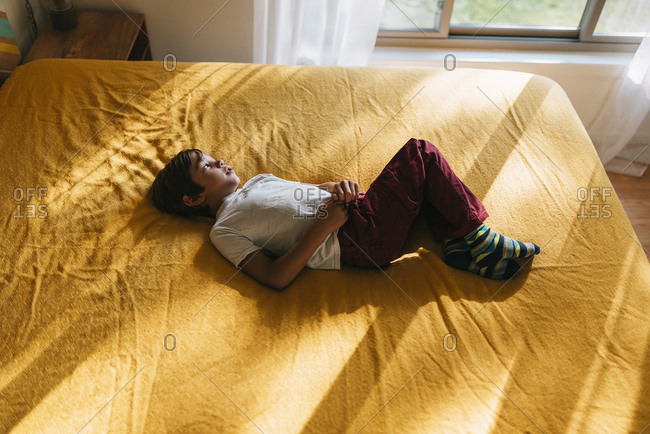 Portrait of a young boy playing on a bed