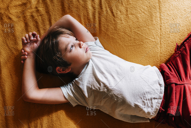 Portrait of a young boy playing on a bed