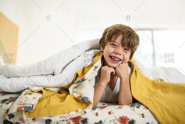 Portrait of a young boy playing on a bed