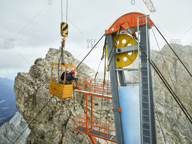 Germany- Bavaria- Garmisch-Partenkirchen- Zugspitze- installers working on goods cable lift in a work cage