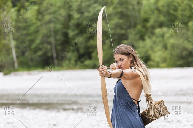 Archeress aiming with a bow in the nature