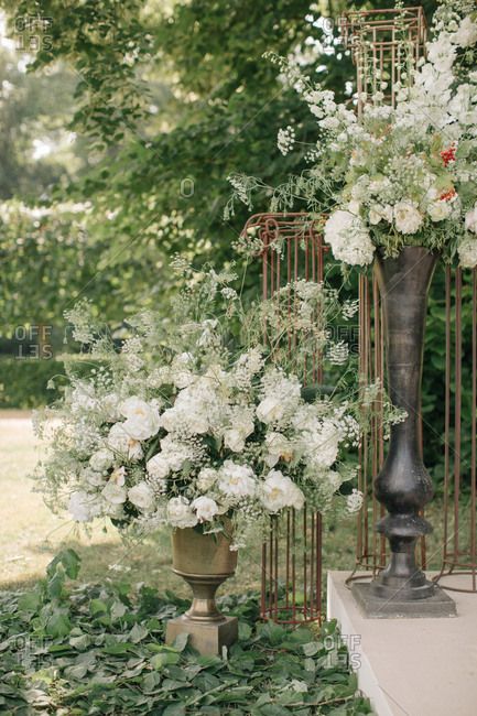 Large urns with white flowers at a wedding ceremony