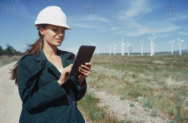 Environmental specialist with tablet computer at the wind turbines site