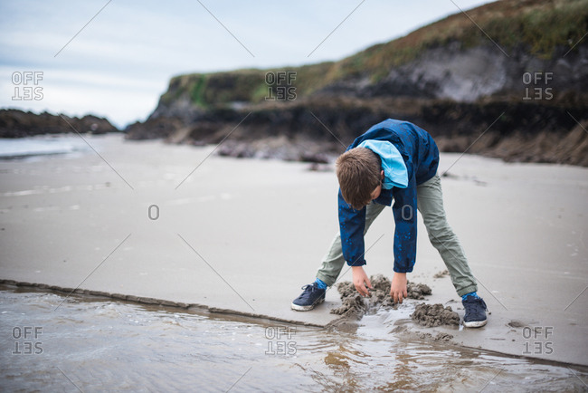 Boy playing in the sand on the beach