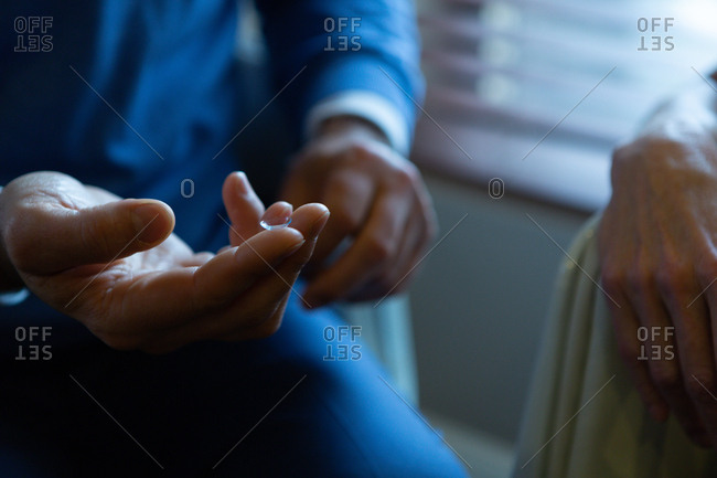 Optometrist holding contact lens on finger in clinic