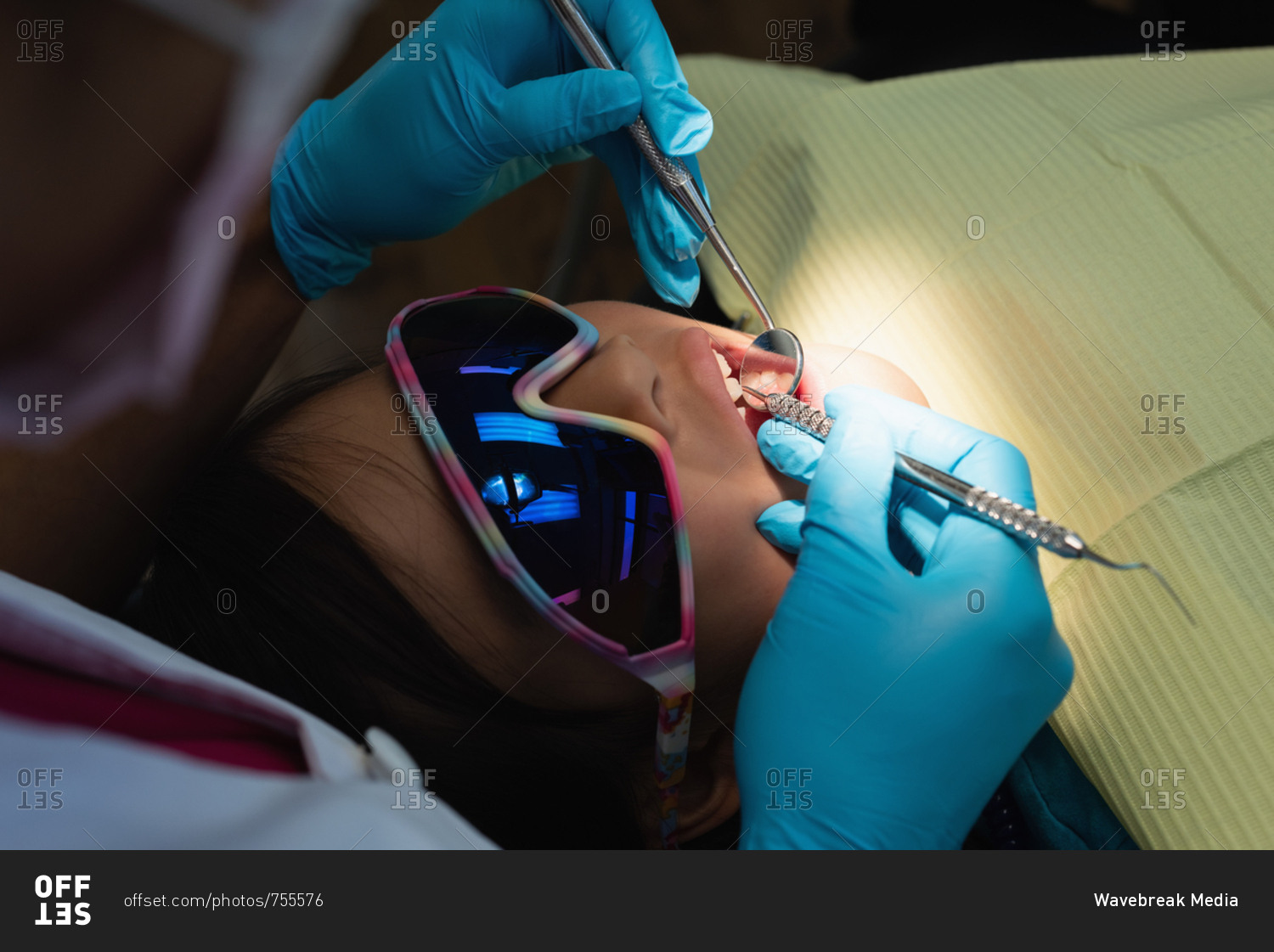 Female dentist examining a patient with tools in dental clinic
