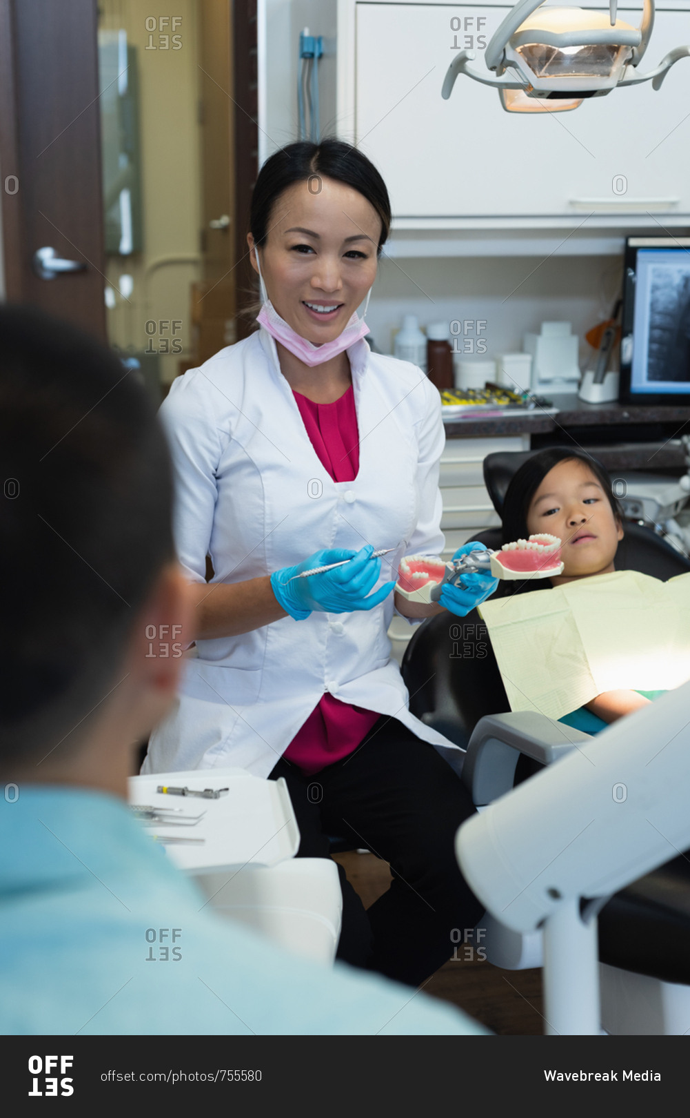 Female dentist interacting with a patients father in clinic