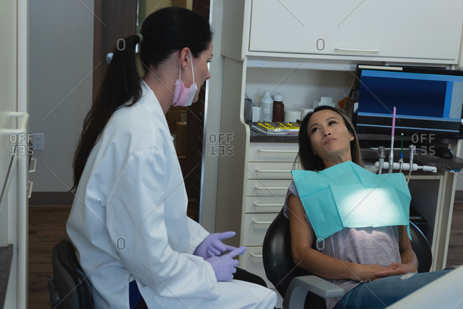 Female dentist interacting with patient in clinic