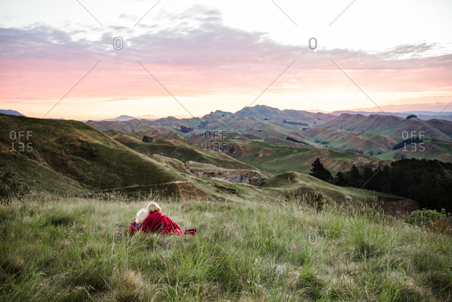 Children sitting on a blanket watching the sun set