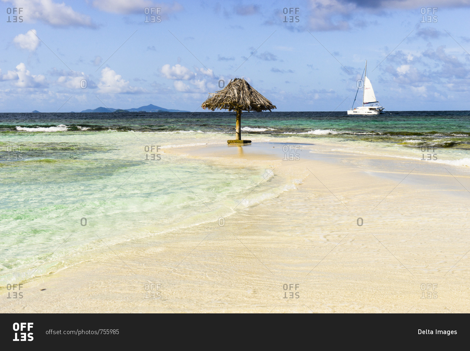 Straw hut ont the Morpion's island beach and a boat sailing, St-Vincent, Saint Vincent and the Grenadines, Lesser Antilles, West Indies, Windward Islands, Caribbean, Central America