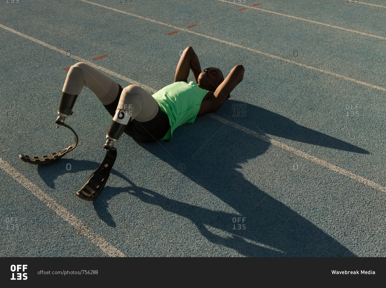 Tired disabled athletic relaxing on a running track