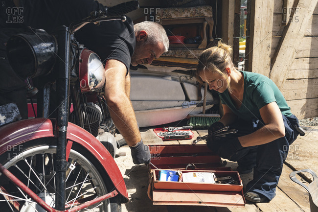 Mechanic repairing motorbike in repair garage