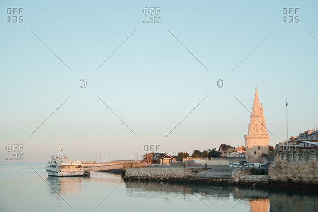 La Rochelle, France: 26 August 2018: Embankment at the La Rochelle city on the coast of Atlantic ocean with medieval fortification towers. Early morning, sunrise