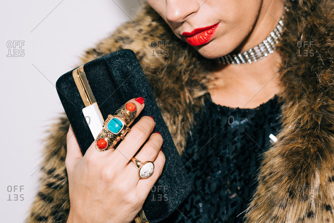 Dressed up woman in fur jacket holding her clutch bag