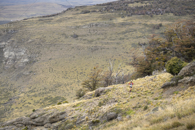 April 9, 2017: Distant view shot of man trail running in natural setting in Torres del Paine National Park, Magallanes region, Chile