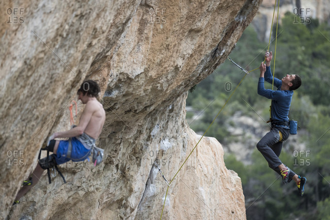 March 4, 2018: Side view of two adventurous men rock climbing, Siurana, Catalonia, Spain