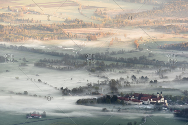 The cloister of Benediktbeuren with surrounding place with early morning fog.