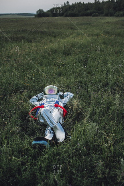 Spaceman exploring nature- relaxing in meadow