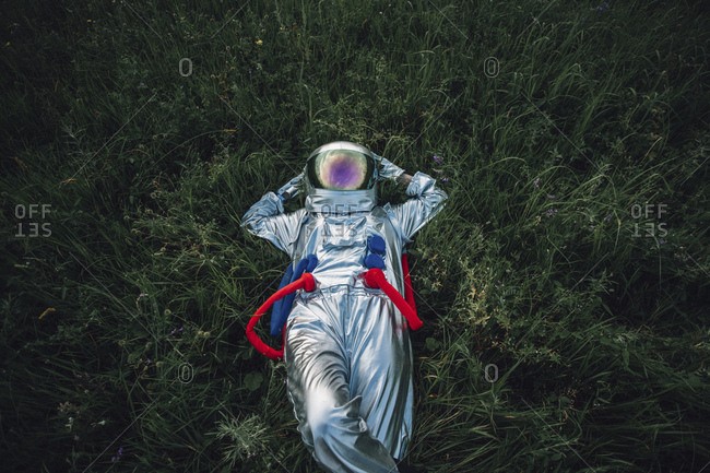 Spaceman exploring nature- relaxing in meadow