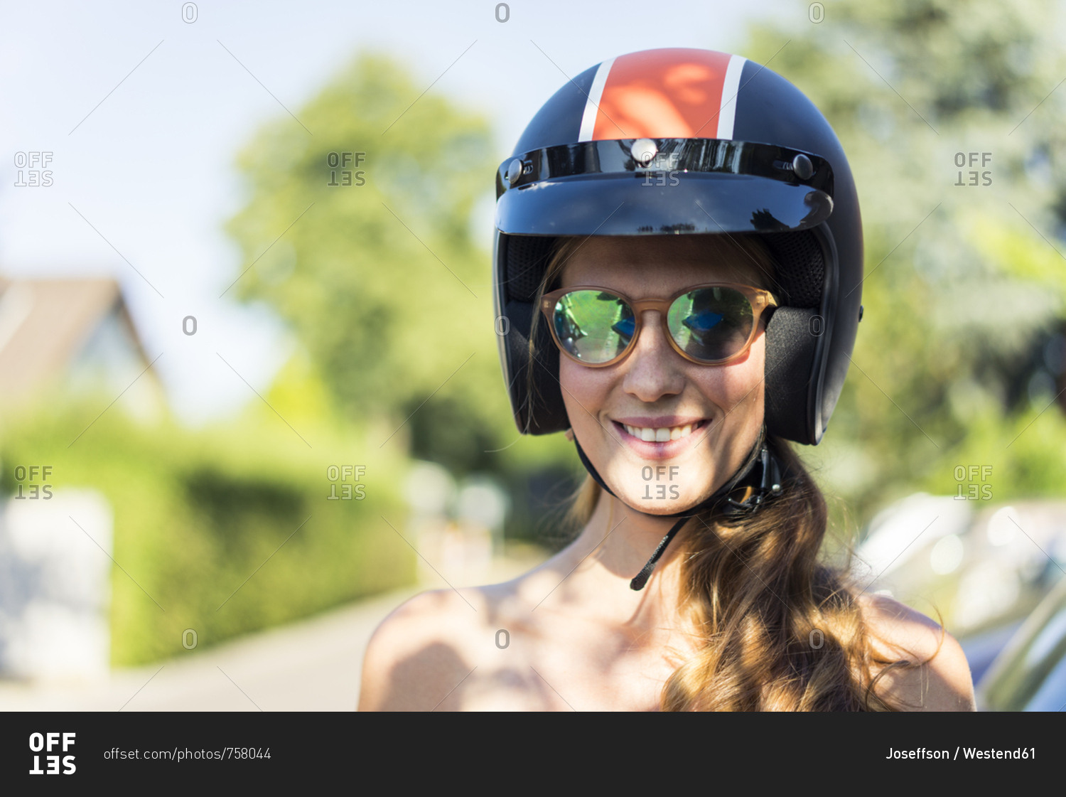 Portrait of smiling woman wearing sunglasses and motorcycle helmet