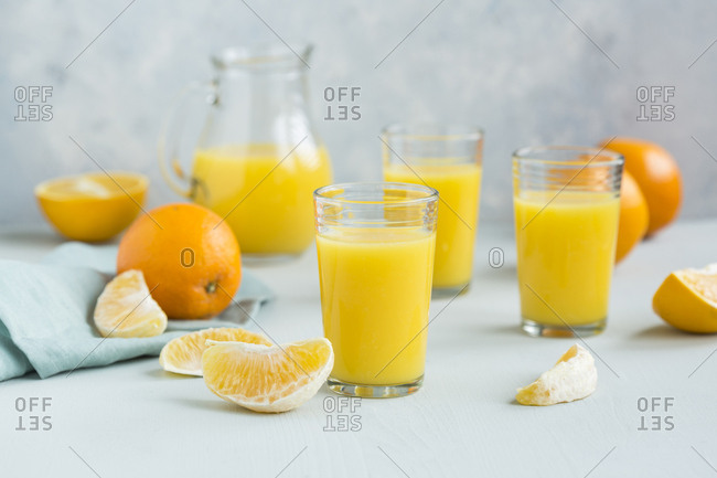 Glasses of freshly squeezed orange juice and orange slices