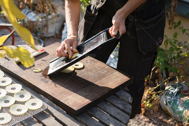 Close-up of person slicing fruit with a mandoline
