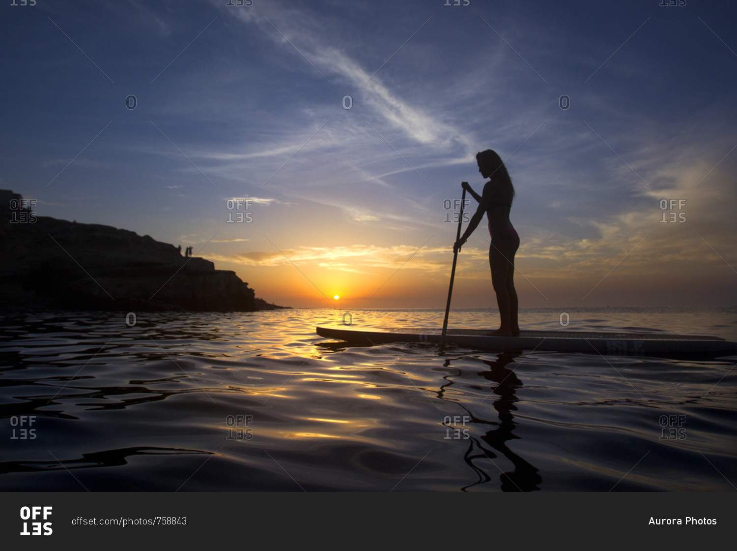 Side view of woman?paddle boarding?ion Pacific Ocean?at sunset, La?Jolla, San Diego, California, USA