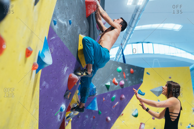 Young woman preparing herself in a climbing gym - preparation, concentration, sportive concept