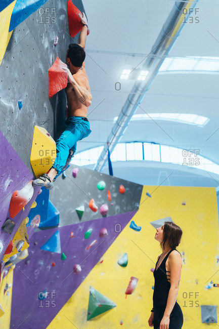 Young woman preparing herself in a climbing gym - preparation, concentration, sportive concept