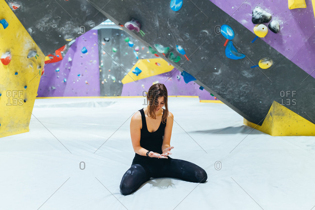 Young woman climbing rock wall indoor - sportive, athletic, balance concept