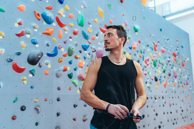Young man preparing the wall for climbing in the gym - preparation, concentration, sportive concept
