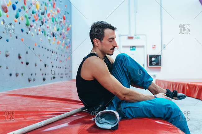 Young man preparing the wall for climbing in the gym - preparation, concentration, sportive concept