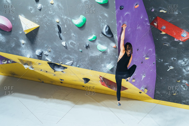 Unrecognizable young woman preparing himself in a climbing gym - preparation, concentration, sportive concept