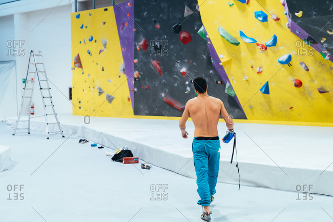 Young man preparing himself in a climbing gym - preparation, concentration, sportive concept