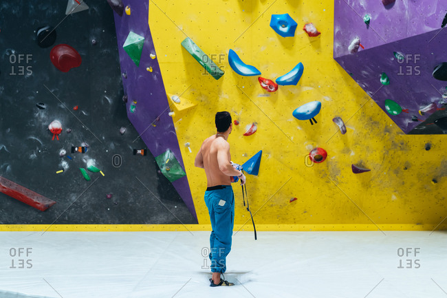 Young man preparing himself in a climbing gym - preparation, concentration, sportive concept