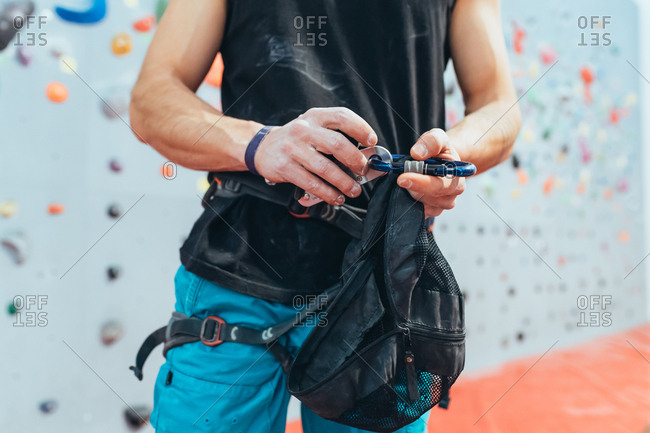 Young man preparing himself in a climbing gym - preparation, concentration, sportive concept