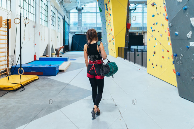 Young adult man and woman preparing with rope for climbing wall - exercise, preparation, sport concept