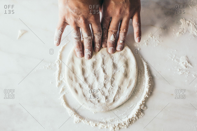 Man kneading dough with fingers
