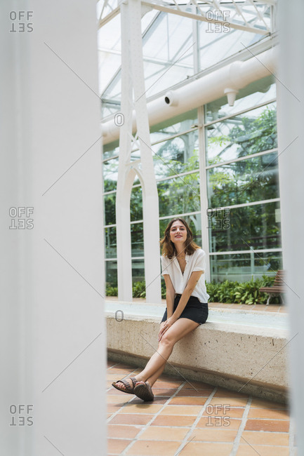 Portrait of a woman sitting in greenhouse